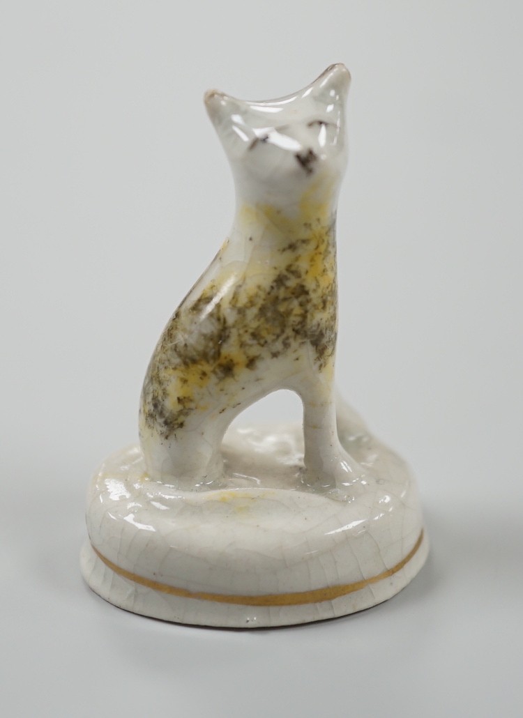 A seated toy Staffordshire model of a cat with tortoiseshell markings, c.1830-50. 4.5cm tall, Provenance: Dennis G.Rice collection